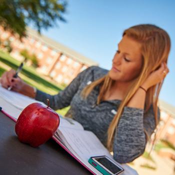Female Student Studying Outside with Textbook Female Student Studying Outside with Textbook