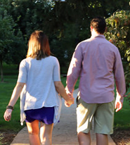 Couple Holding Hands on Front Lawn of Campus